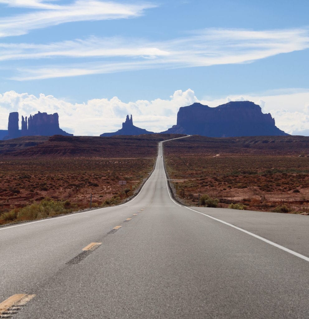 long road leading down into mesas in Monument Valley