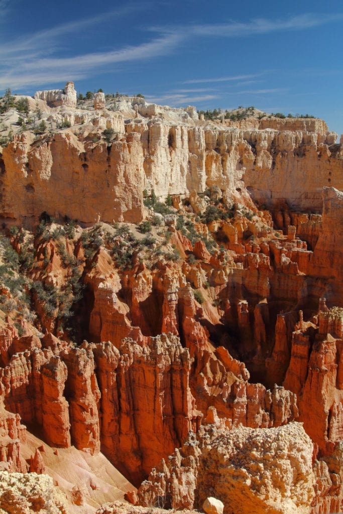 hoodoos that are bright orange and fade to light orange as they reach towards the blue sky