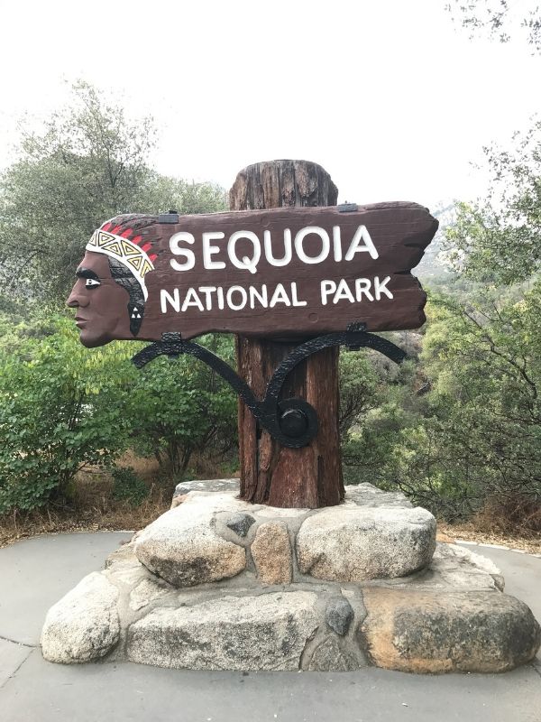 wooden sign with native american face on left sign. sign reads" Sequoia national park"