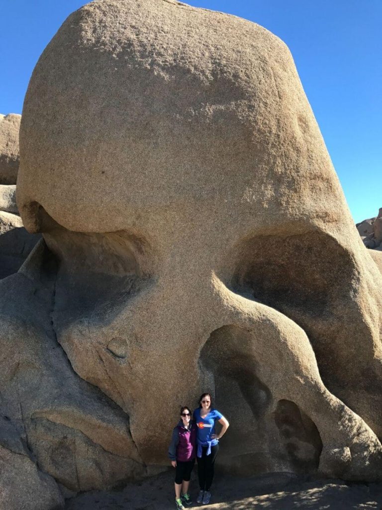 skull shaped rock with 2 ladies standing in front